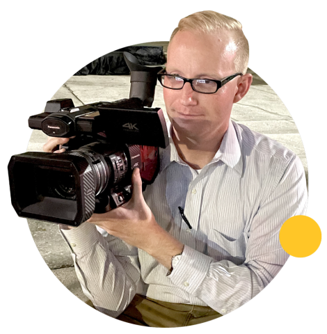 Matthew Wilcox holds up a large production camera.